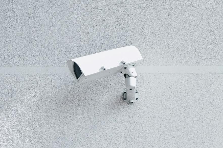white box security camera on wall